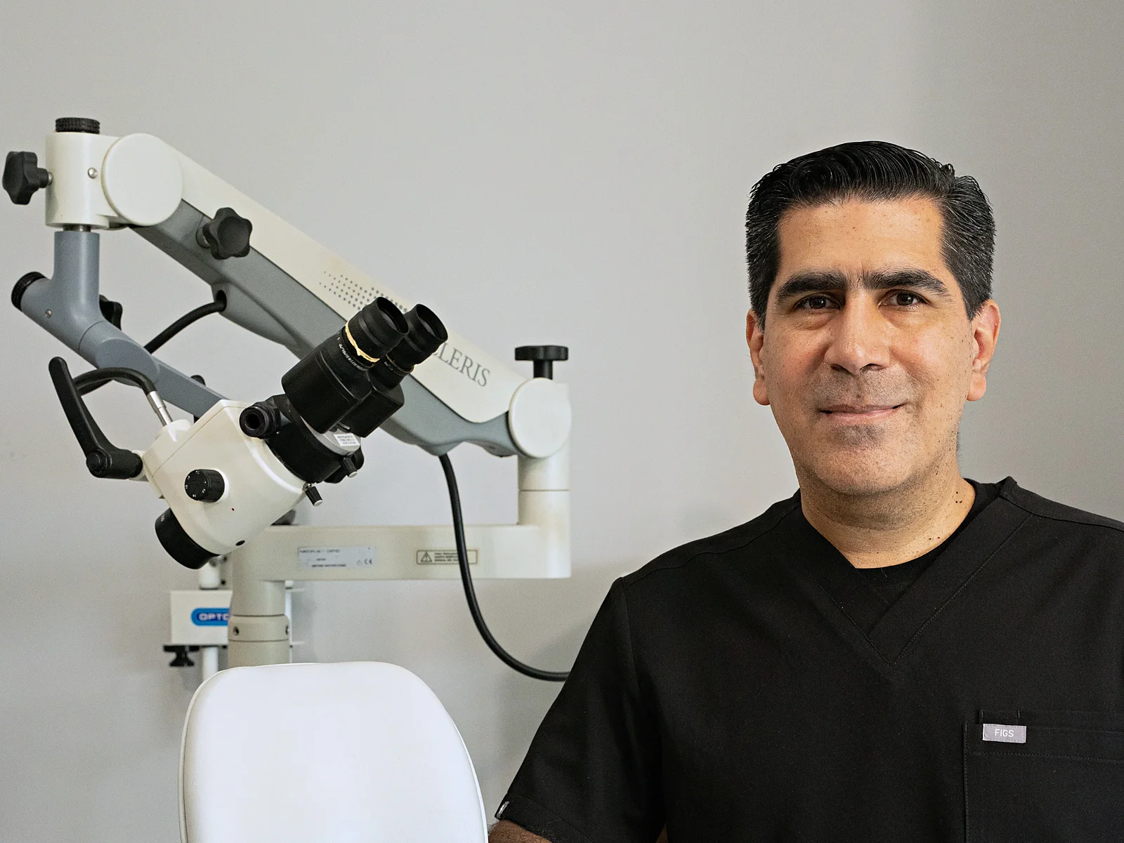 El Dr. Montalvo en el cuarto de exploración, junto al microscopio