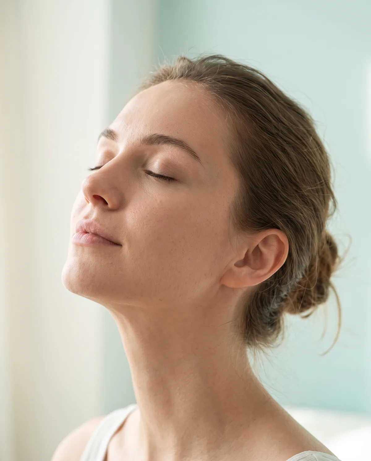 Mujer de perfil con el rostro ligeramente elevado, respirando profundamente — cirugía nasal funcional y estética en Cancún